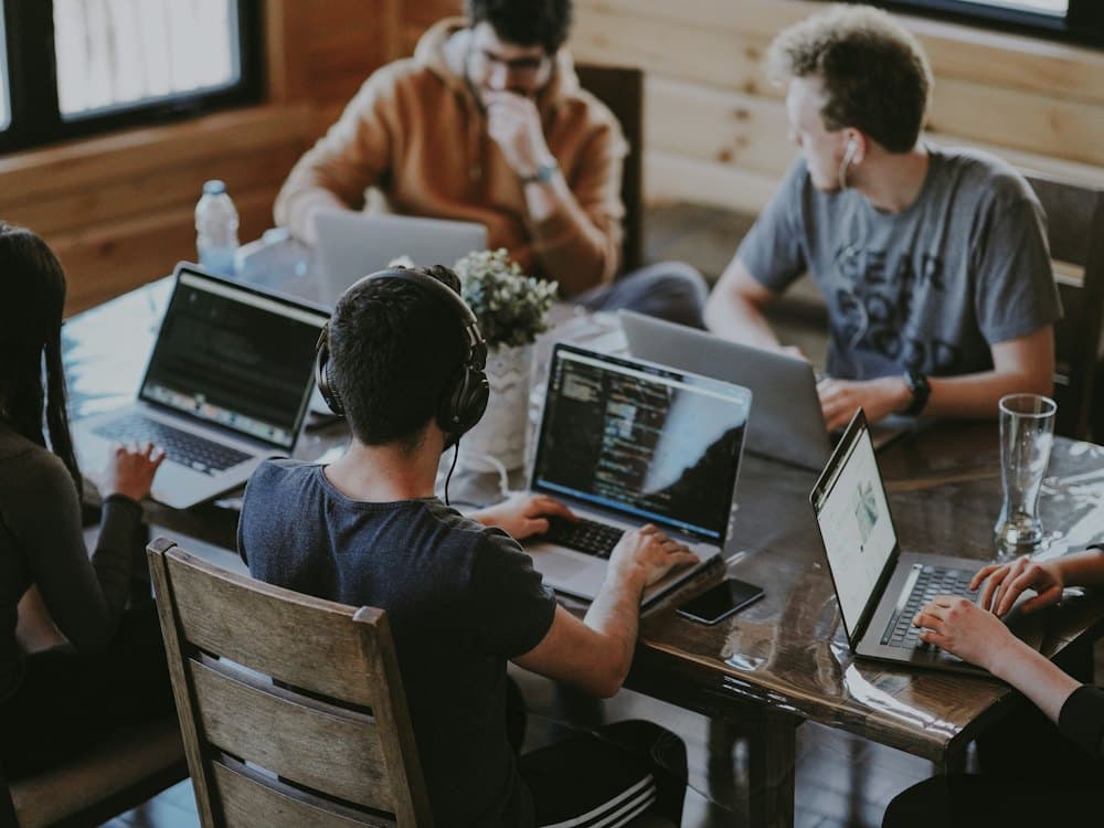 A team working together around a table with laptops